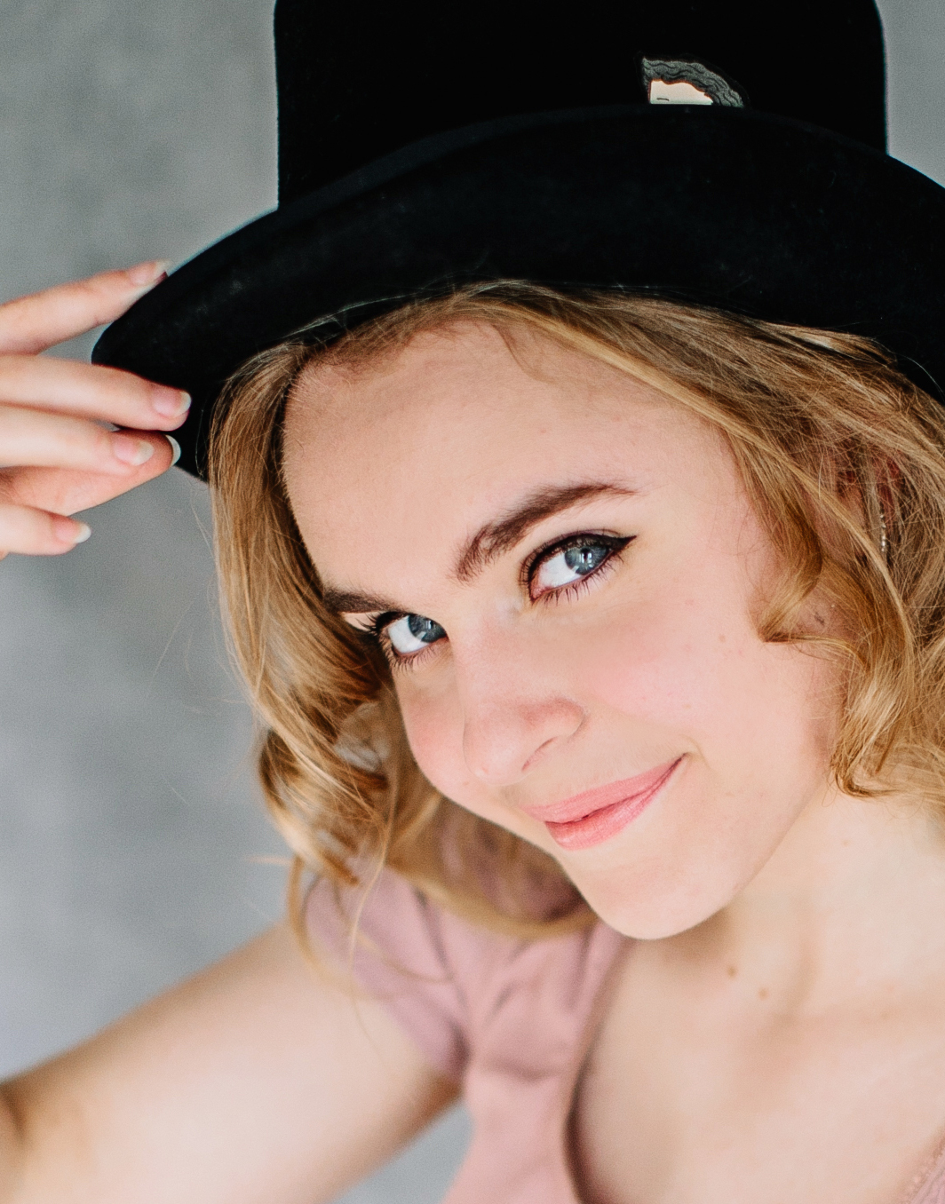 Elleina with a top hat smiling at the camera