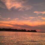Picture of an orange and red sunset over water.